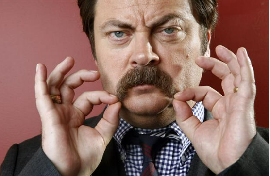 Ron Swanson scowls and plays with his signature moustache