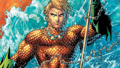 Aquaman stands, holding his trident, in front on a large wave.