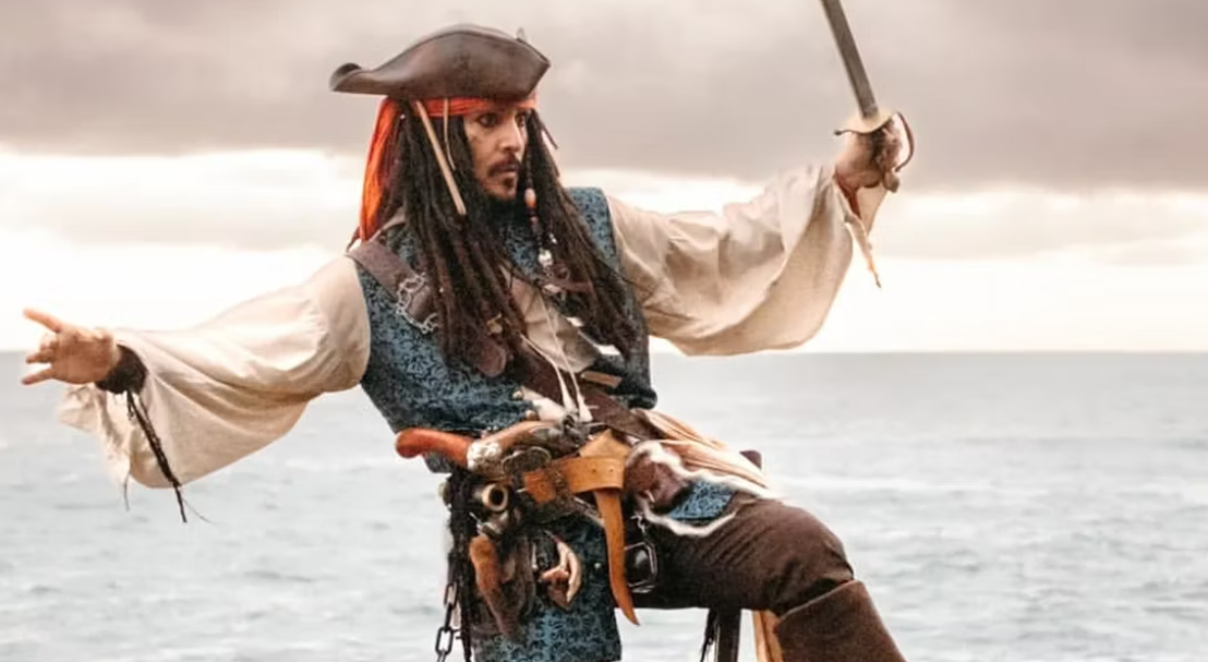Jack Sparrow, wielding his sword, leans back and and waves his arms in a wild and eccentric manner.