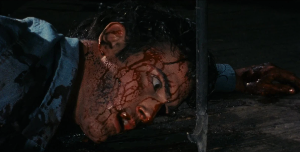 Ash Williams, bloodied and face down on the floor, stares at a fireplace poker than has landed next to his face. He stares in horror at the instrument that missed his head. 