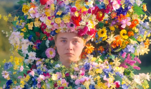 Dani (Florence Pugh) sits covered in flowers as the "May Queen", pouting as she weeps over prior events.