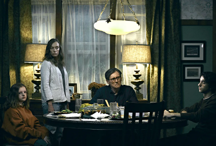 The Graham family are sat around the dinner table, looking removed from each other while sitting at the same table. From left to right: Charlie, Annie, Steve, Peter.