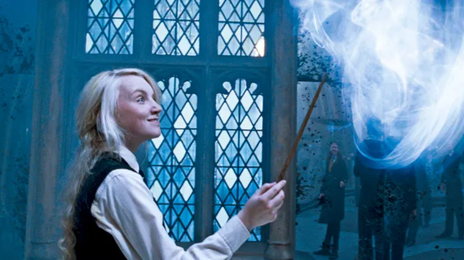 Luna holds her wand up toward the sky, the spell casts a soft and hazy blue cloud above her which she smiles at.