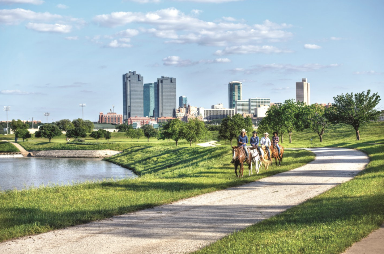 People riding horses on a trail in Fort Worth.