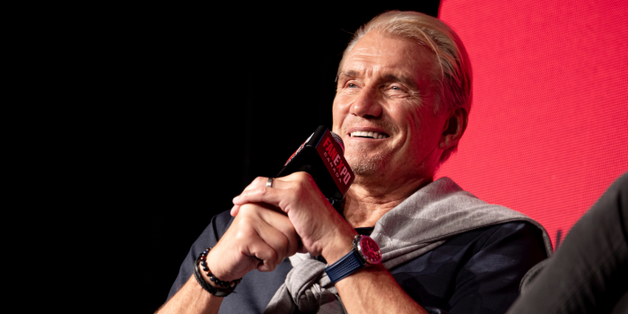 Dolph Lundgren smiles as he speaks into the FAN EXPO Canada branded microphone. 