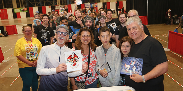 Holding up pictures of Pinky and the Brain, and the Animaniacs, Rob Paulsen and Maurice LaMarche post with the whole crowd of fans waiting for autographs.