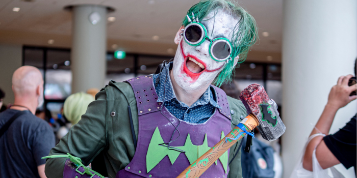 A person dressed as an armoured, Steampunk style Joker poses with their bloodied mallet. 