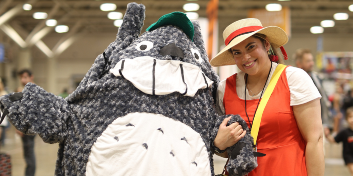 A pair pose for the camera cosplaying as characters from My Neighbour Totoro. Left, is a fan dressed as Totoro, and right, is a fan dressed as Mei.