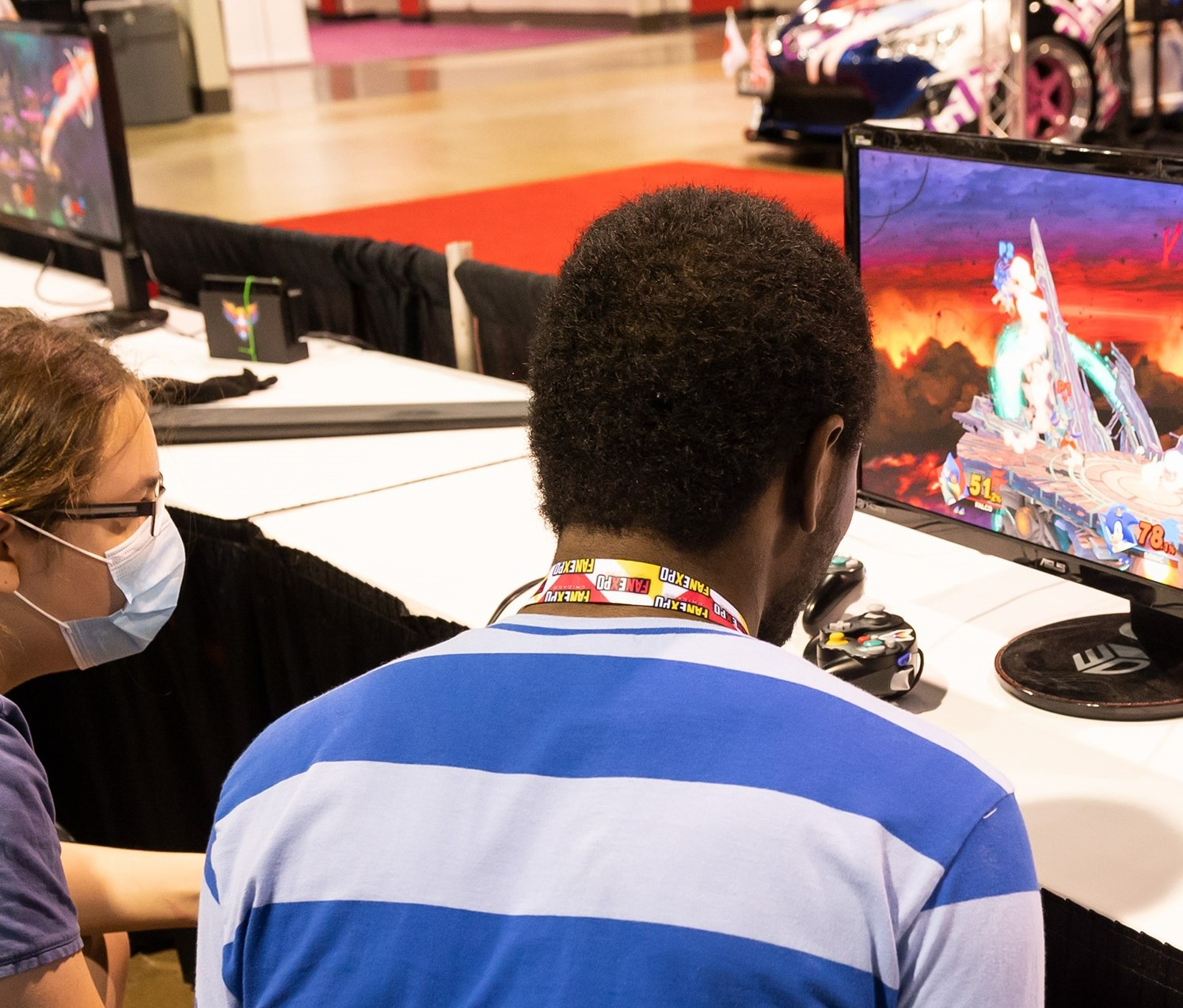Two guys playing. One is wearing a blue and white stripped shirt.