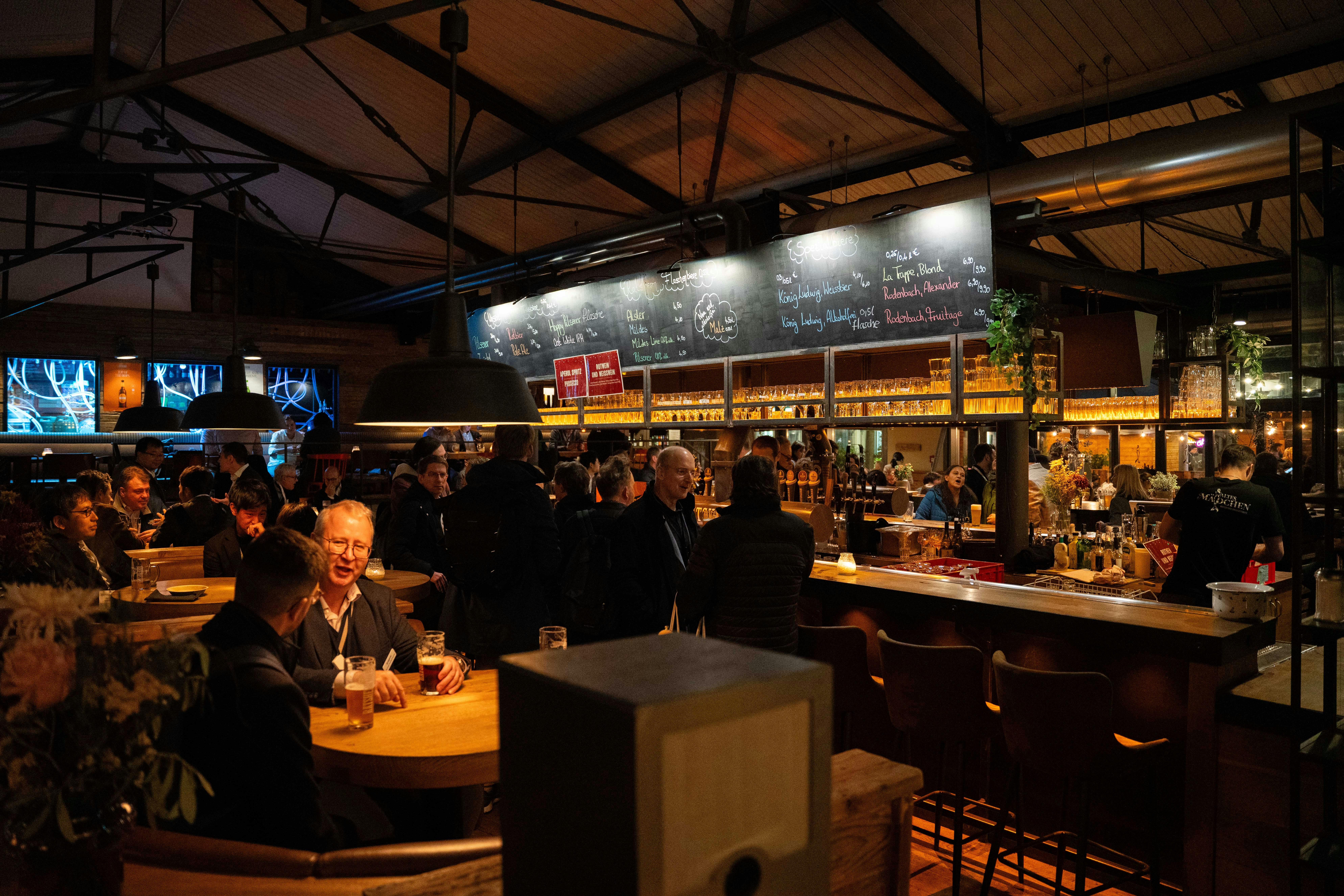 A busy bar scene with many people in conversations.
