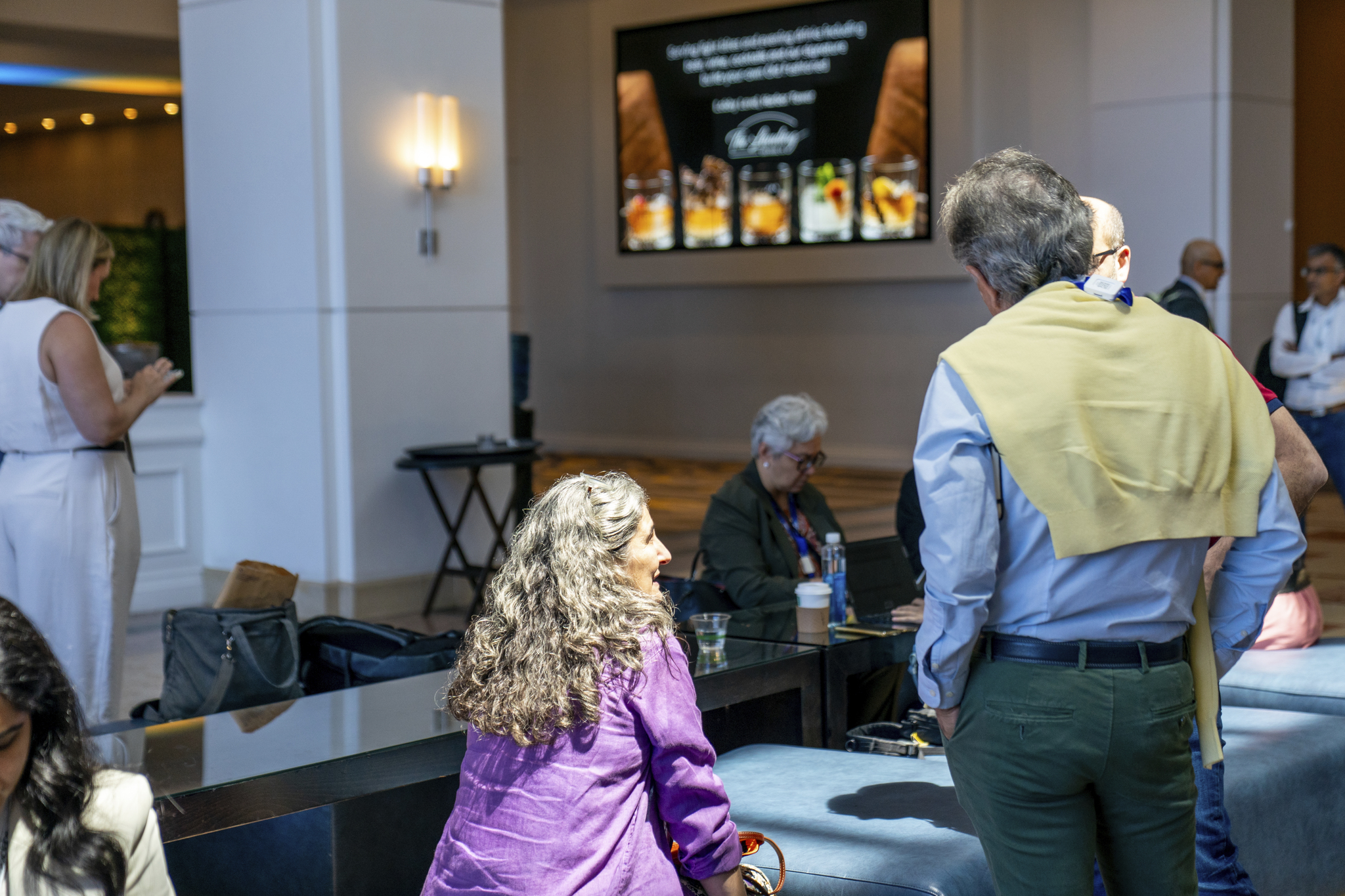 TIDES USA networking hall - A woman and two men networking.