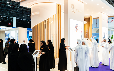 Emirati man using his phone with colleague at Tawdheef