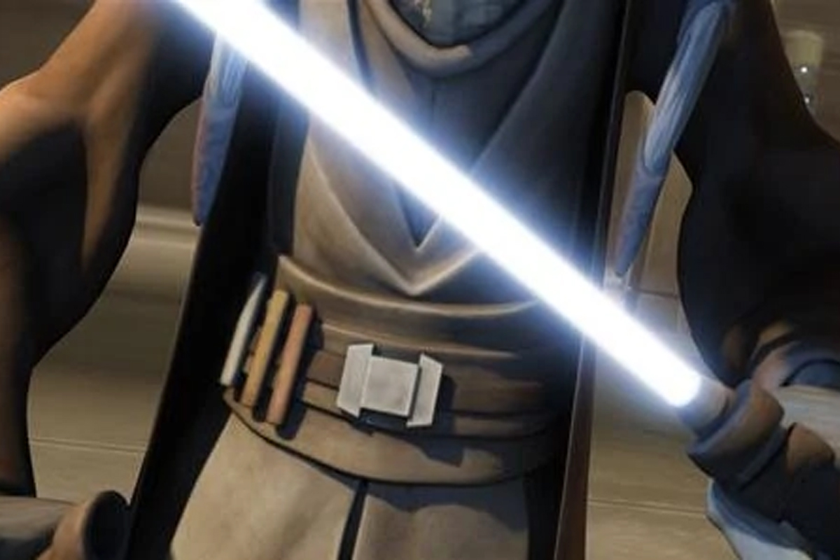 Tera Sinube holding a light blue lightsaber across her chest with brown robes on