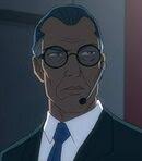 Stan Edgar in a suit and a headset looking off in the distance