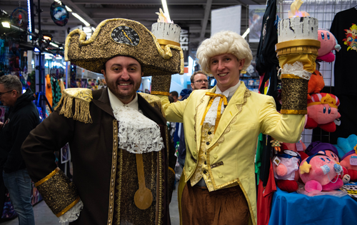 Two cosplayers dressed as Cogsworth and Lumière from Beauty and the Beast