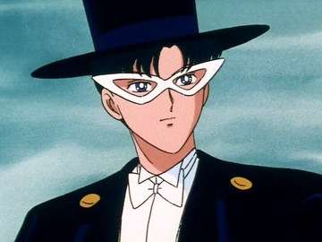 Tuxedo Mask from Sailor Moon is against a blue background and is wearing white glasses, a suit jacket, a white shirt, a black and blue top hat and a white bowtie.
