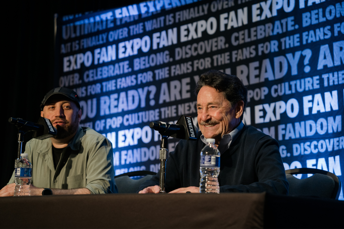 PETER CULLEN SITTING AT A TABLE WITH A MICROPHONE WITH A MODERATOR SITTING NEXT TO HIM