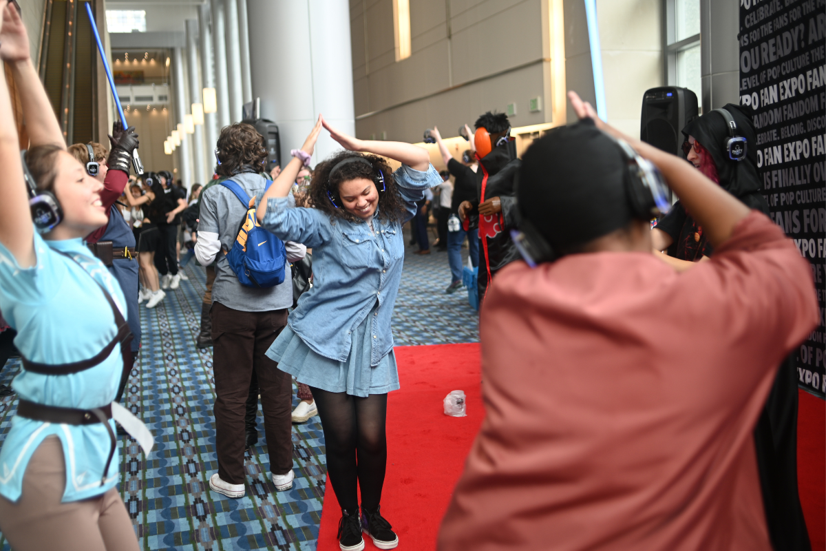 People dancing on the cosplay red carpet with headphones on