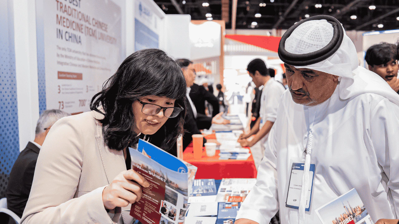 Emirati student receives admissions guidance from a university representative at Najah Abu Dhabi higher education exhibition.