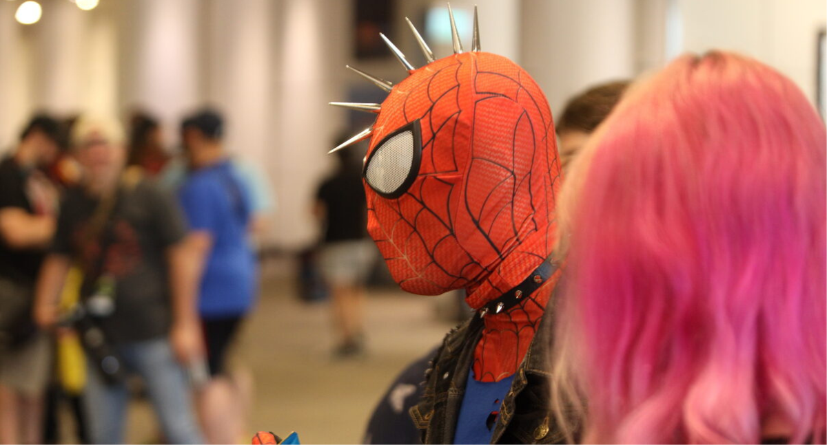 Spiderpunk emerges from a group of fans in the foreground - fans gather in the background