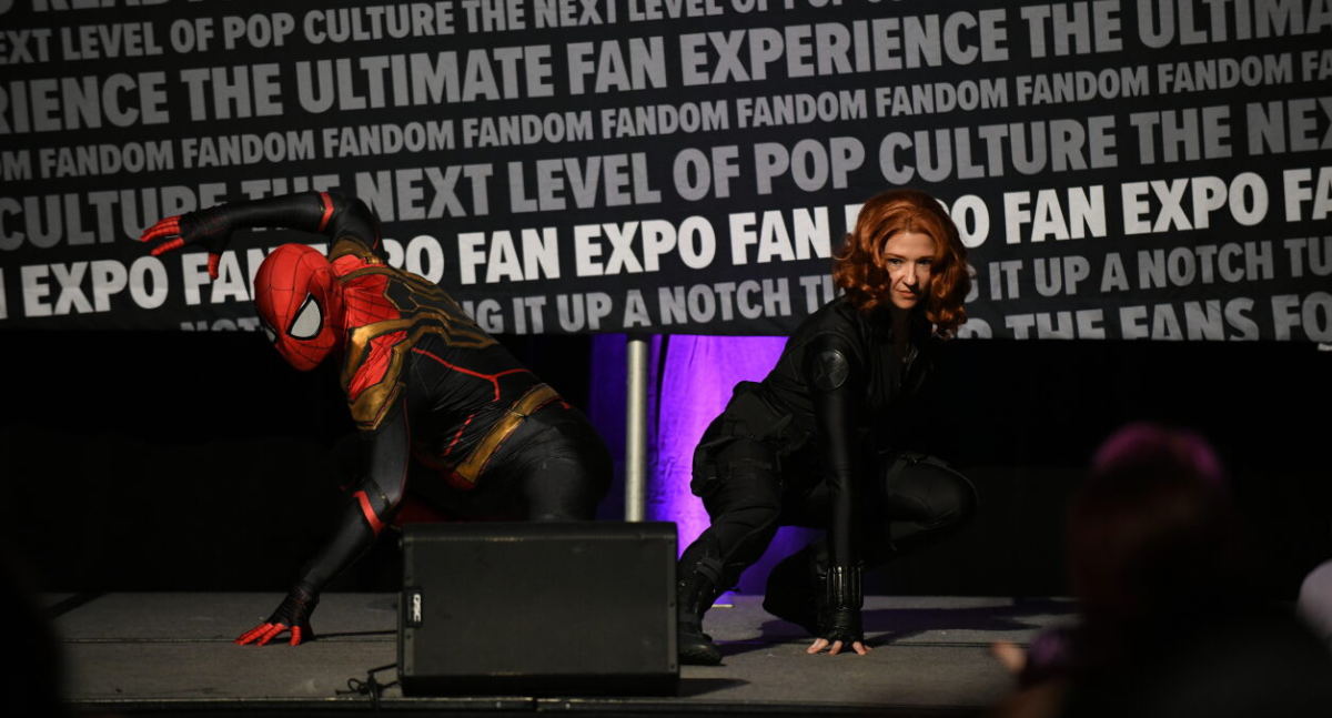 Cosplay Red Carpet Walk on Exhibition: Spiderman and Black Widow crouch in the same pose, holding for the camera