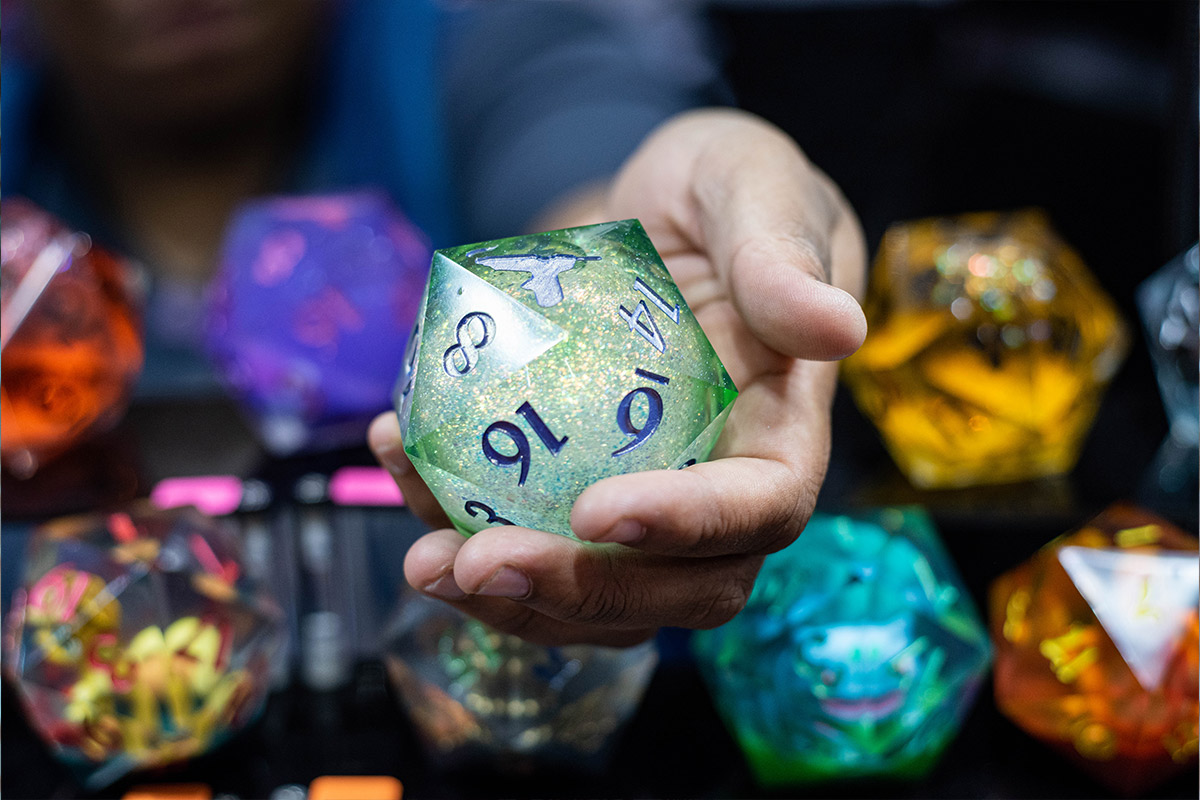 A giant D20 die held up in a vendor's hand