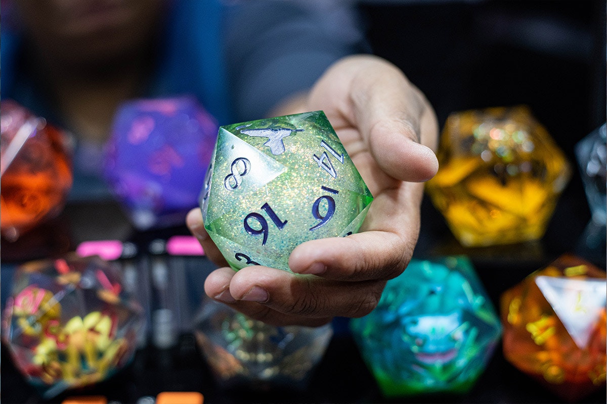 A giant D20 die held up in a vendor's hand