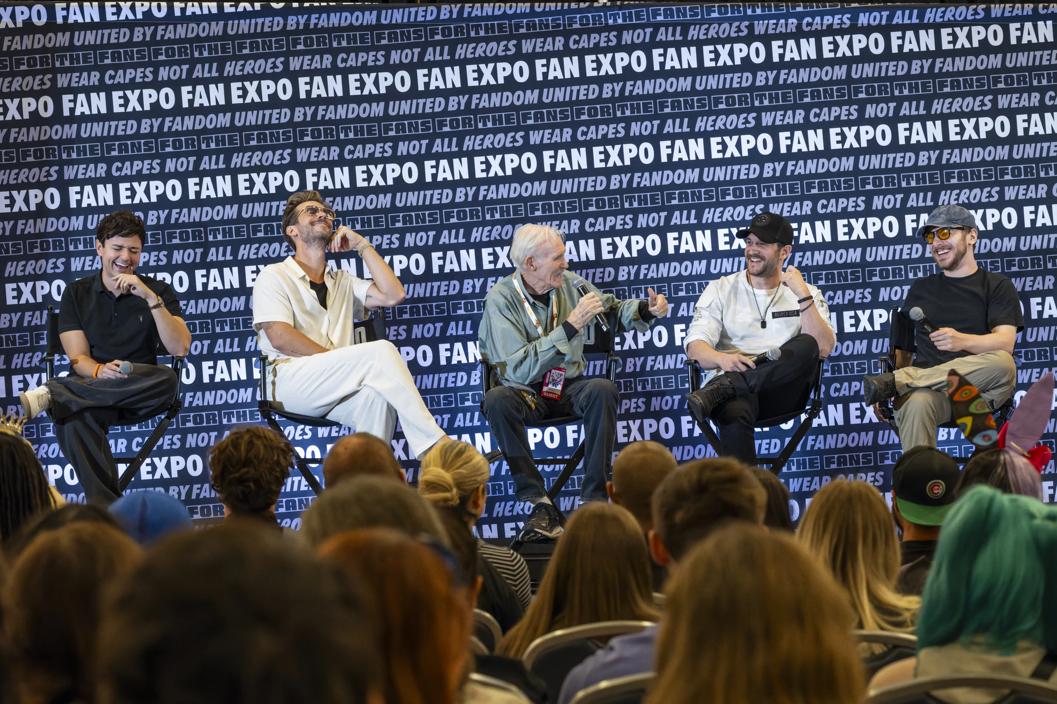 Five Naruto voice actors sit on stage, laughing and joking together during their lively panel.