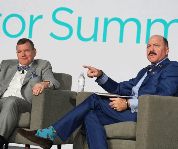 2 speakers having a discussion on stage at the Investor Summit