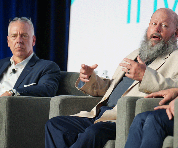 Speaker chatting with another speaker onstage at the Investor Summit
