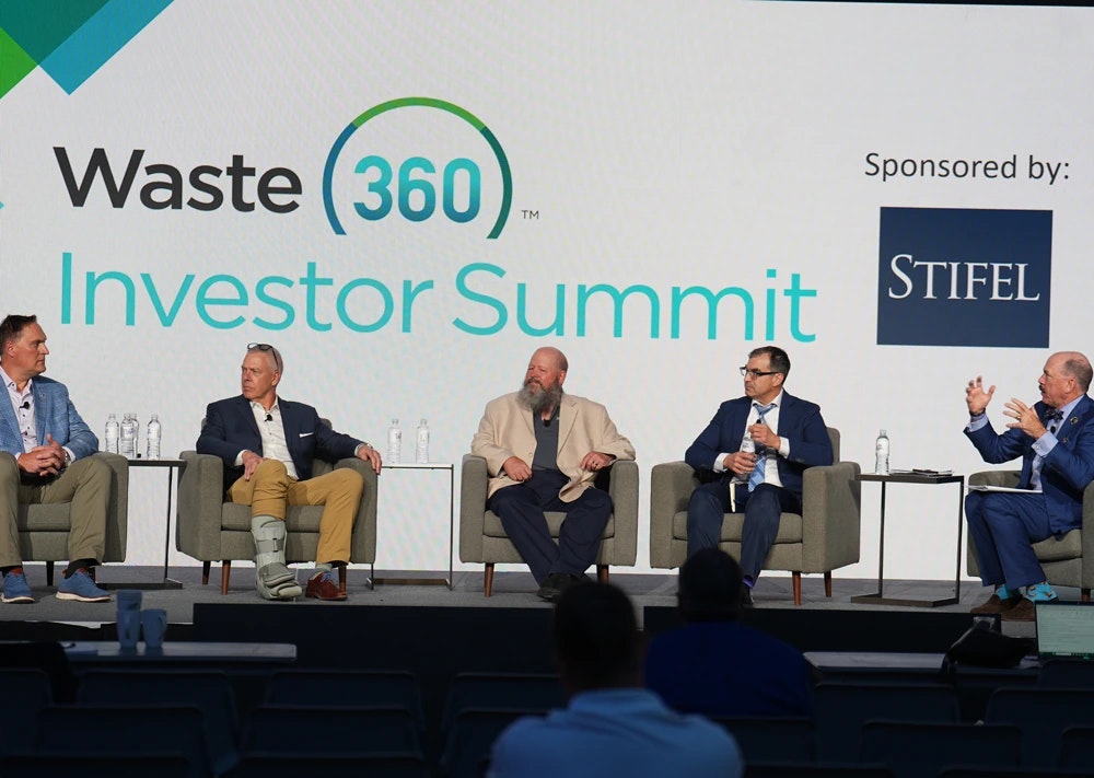 speakers on a stage at a conference