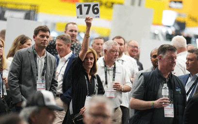 Person standing in a crowd making a bid at the EREF Auction