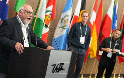 man speaking at podium of international reception