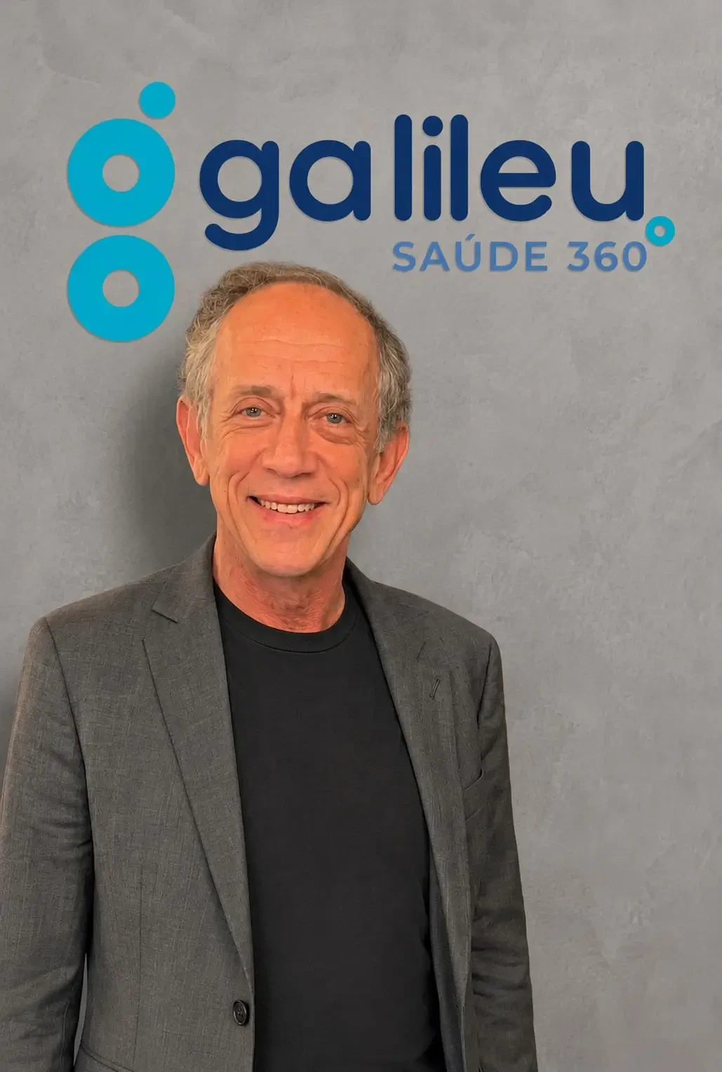 Walter Feldman, palestrante do Healthcare Innovation Show, sorrindo de blazer cinza em frente ao logo da Galileu Saúde 360.