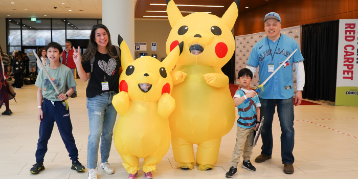 Family Cosplay! From left to right: Son swinging a minecraft sword, mom holds up a peace sign, a mini and a major Pikachu (siblings) stand in the centre, a little link to their left, and dad on the far right