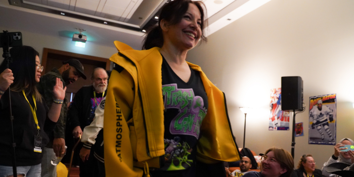 The voice cast of the original X-Men: The Animated Series surprise fans at the premiere screening of X-Men '97 at Toronto Comicon. Alyson Court leads, followed by Lenore Zann, and George Buza. Fans looks on in excitement from the sides.