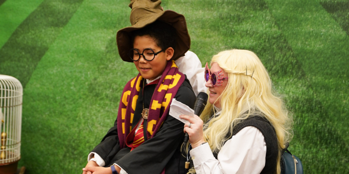 A child, dressed in full Gryffindor garb, is seated for his house sorting with Luna Lovegood and the Ontario Order of the Phoenix