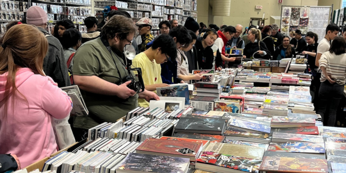 Crowds collect around a vendor to shop all kinds of book titles.