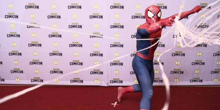 Spider-Man lands on his feet, and slings his web out into the crowd, and at the camera