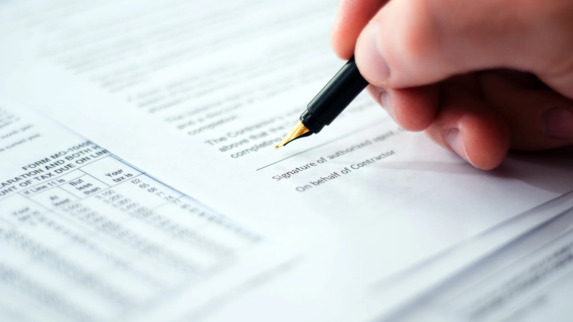 Close-up of a hand signing an EPC contract, illustrating value leakage in energy contract negotiation