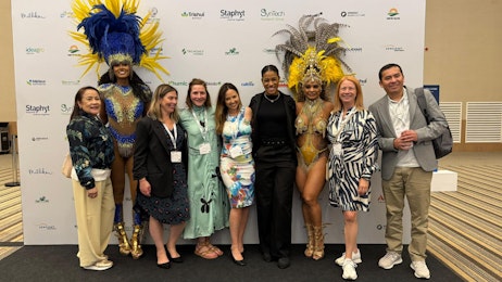 Group of people and carnival dancers in front of the Media board at Biocontrol & Biostimulants LATAM