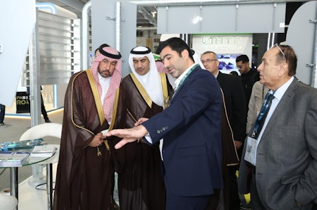 Delegates touring exhibitor stands showcasing smart mobility and road safety solutions at Saudi Intermobility Expo 2024.