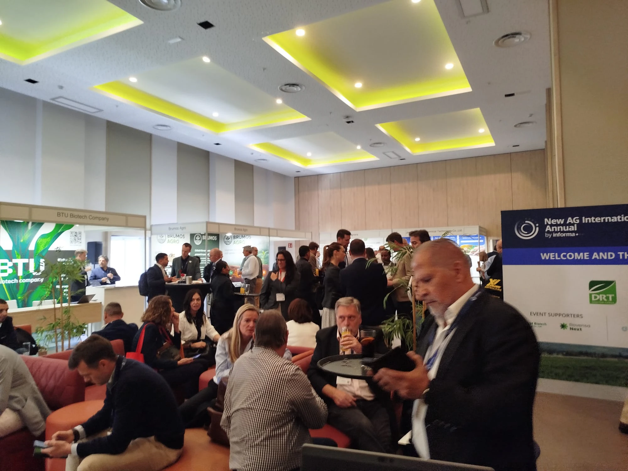 Attendees at the New Ag International Annual networking reception, engaging with industry professionals in an elegant conference setting.