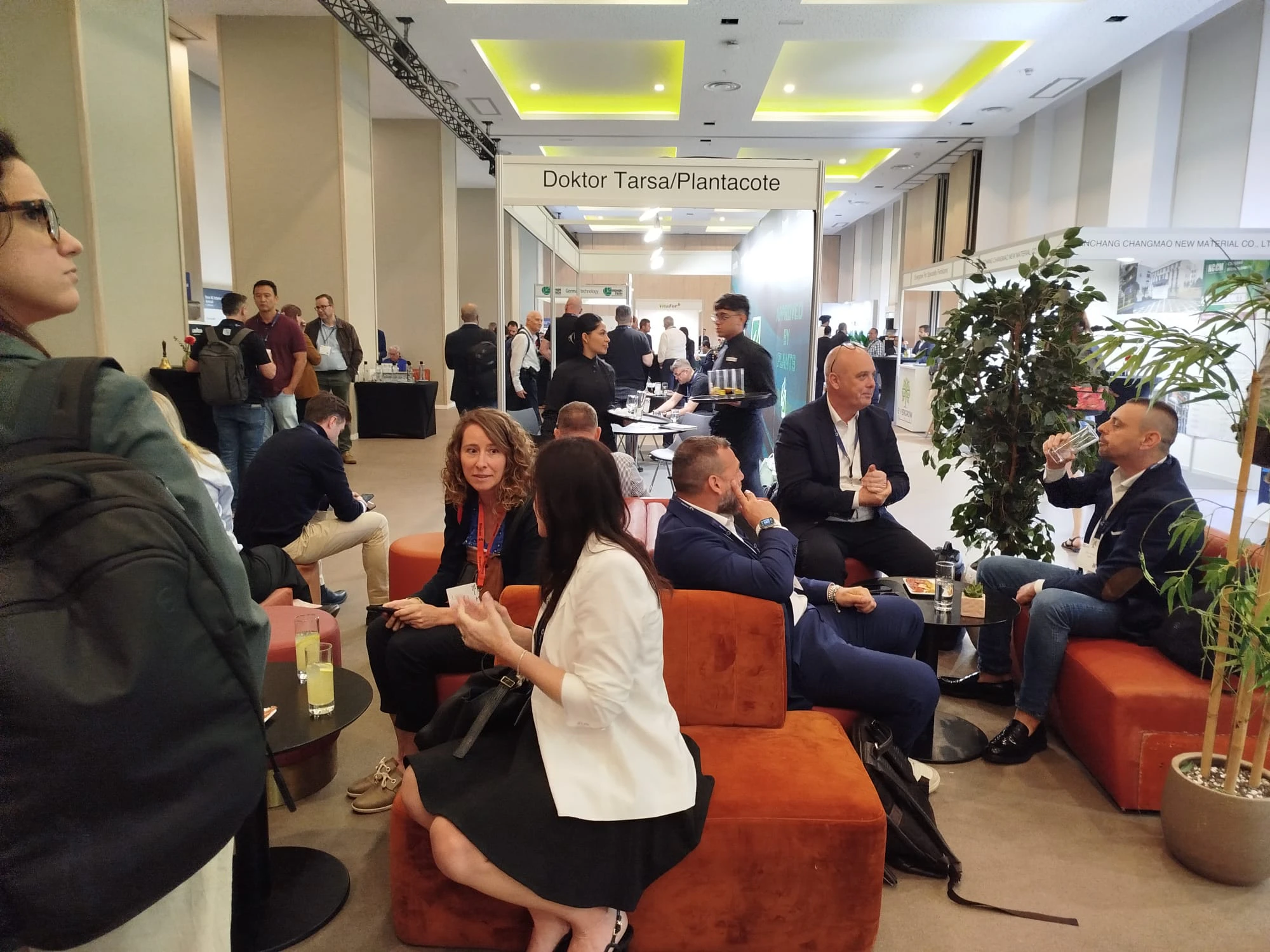 Industry professionals engage in discussions at a BioAg exhibition booth during the New Ag International Annual, connecting with distributors and suppliers.