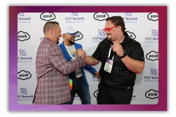 A photo of three men shaking hands and laughing at a networking event