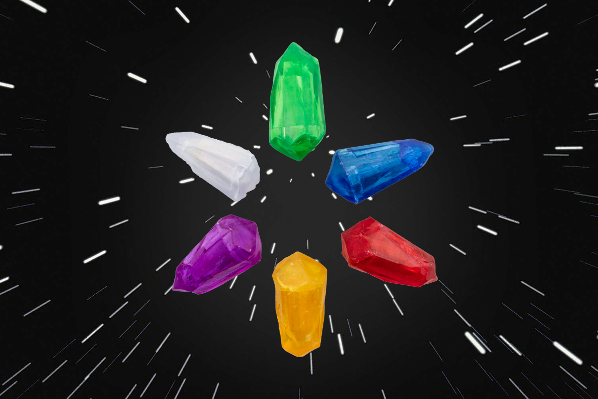 A group of small plastic crystals in a circle coloured (Top, L-R) Yellow, Purple, White, Green, Blue, Red