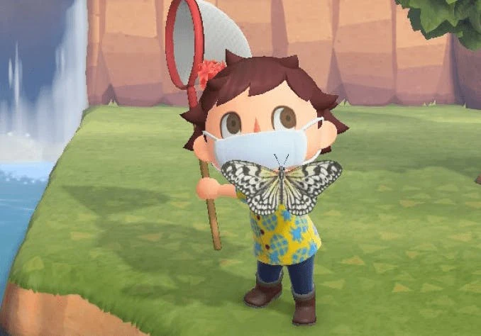 An animal crossing villager wearing jeans and a pineapple yellow shirt and a mask holds up a butterfly to the camera