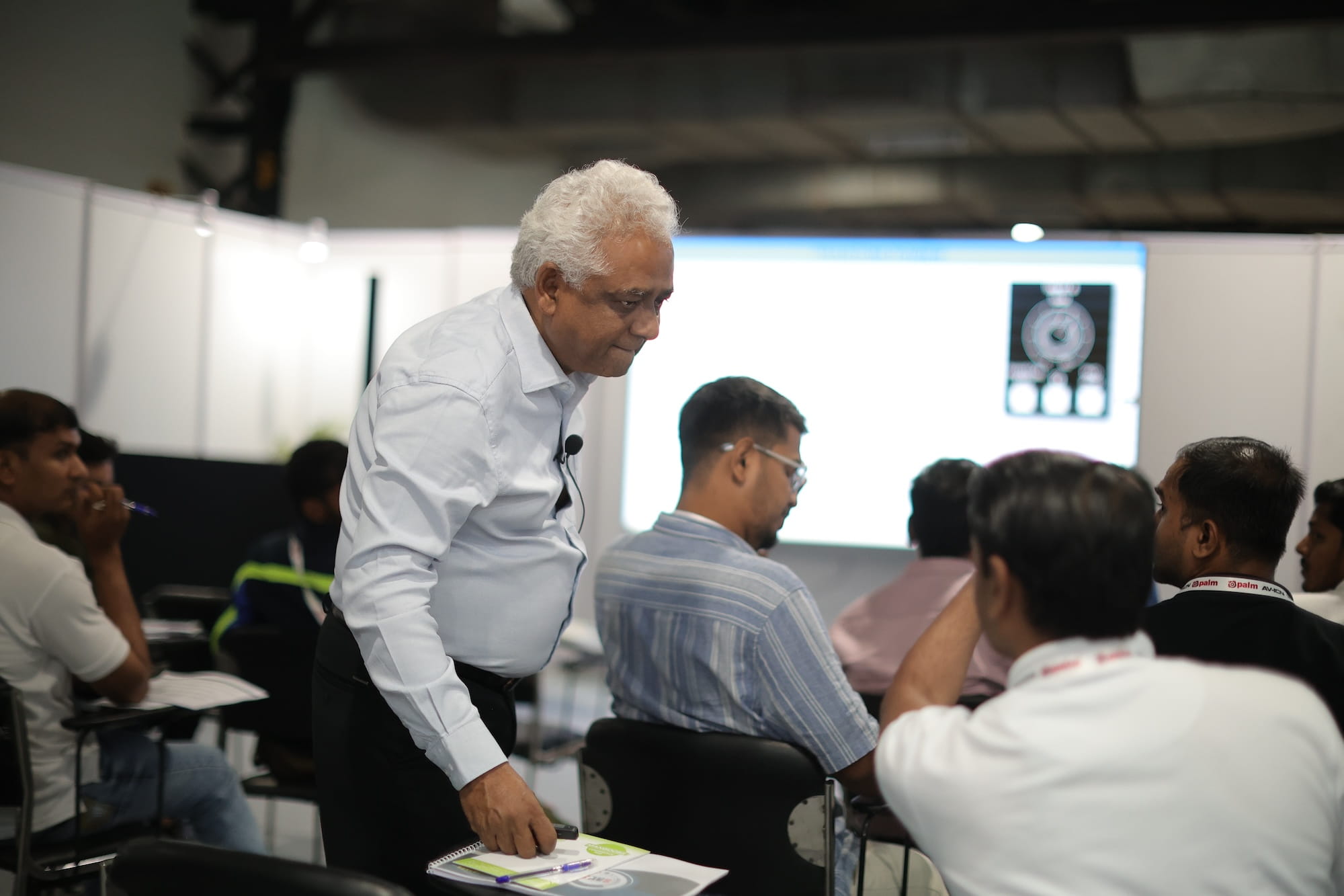 Senior professional speaking to seated attendees during a CAVS Training Program session.