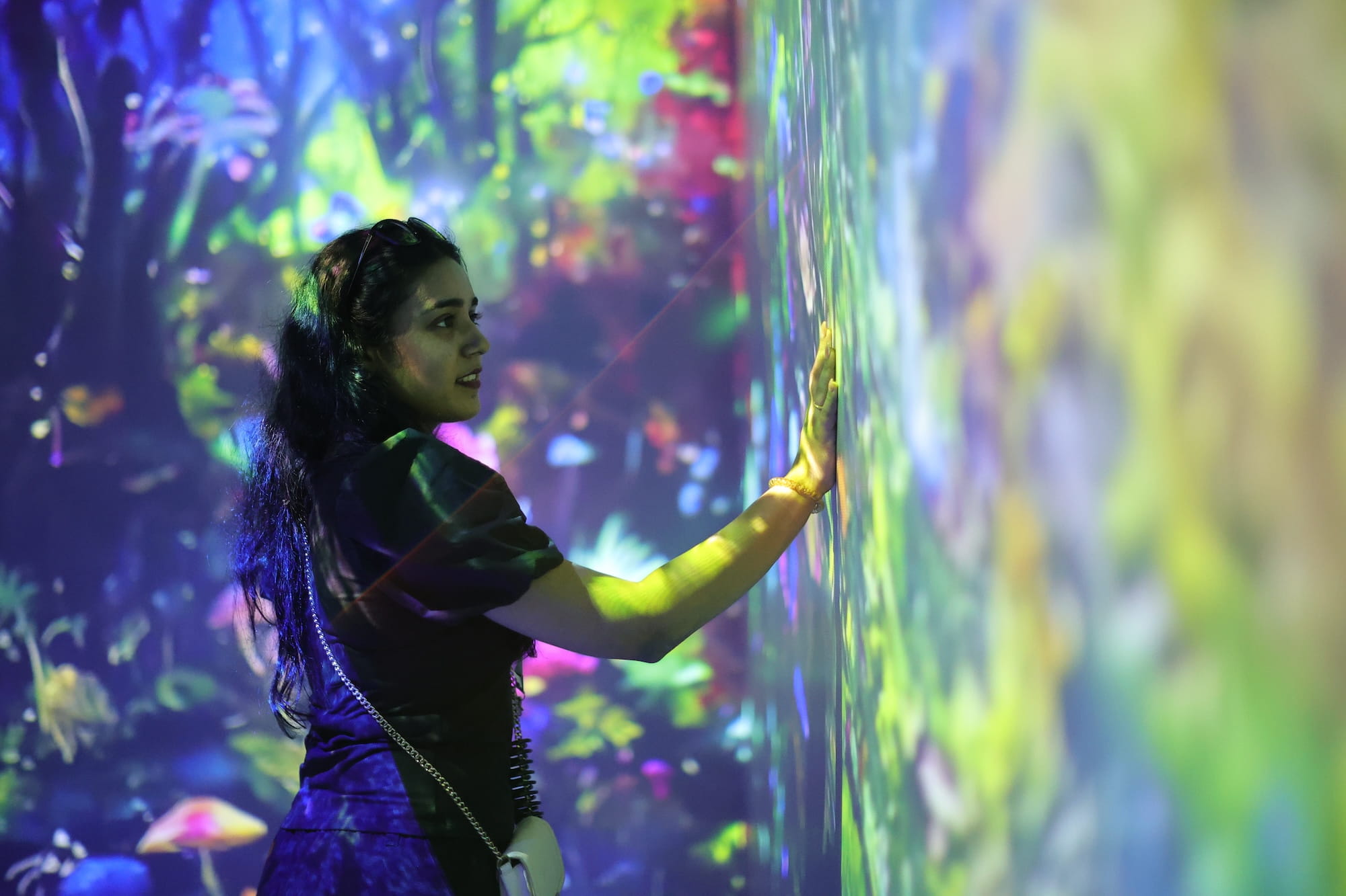 Person interacting with a colorful digital art installation.