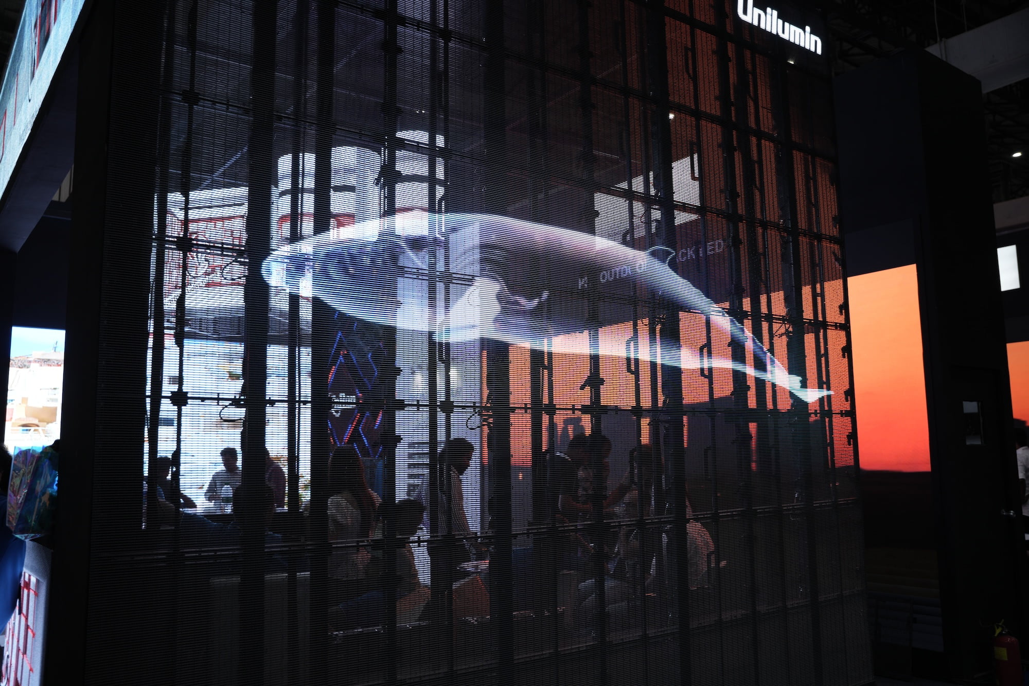 Digital whale projection on a transparent display with people viewing the installation.